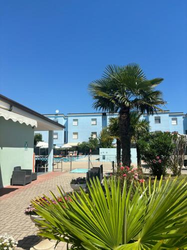 a palm tree in a courtyard next to a building at Long Beach Village Residence sul mare spiaggia privata inclusa in Lido Adriano