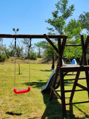 a playground with a swing and a slide at Long Beach Village Residence sul mare spiaggia privata inclusa in Lido Adriano
