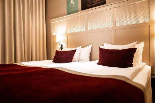 a bedroom with a large bed with red and white pillows at Scandic Grand Central in Stockholm