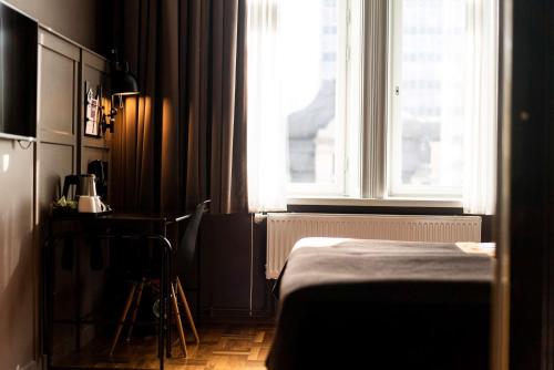 a bedroom with a bed and a window and a table at Scandic Grand Central in Stockholm