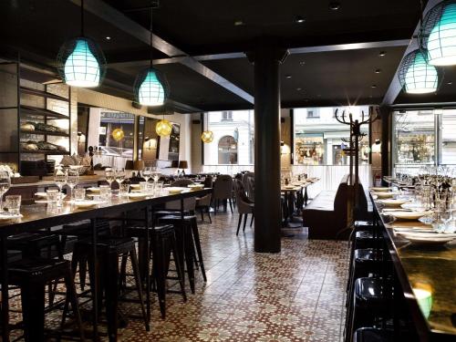 a restaurant with long tables and chairs and lights at Scandic Grand Central in Stockholm
