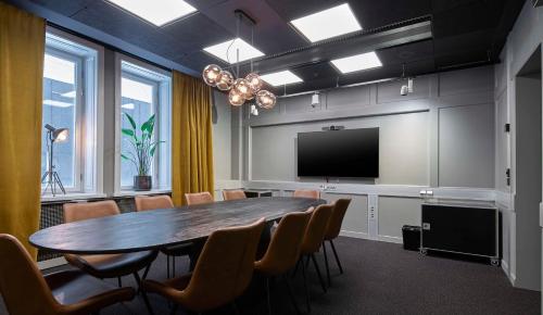 a conference room with a table and a flat screen tv at Scandic Grand Central in Stockholm