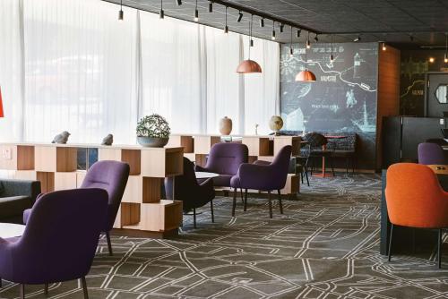 a waiting room with purple chairs and a table at Scandic Kungens Kurva in Stockholm