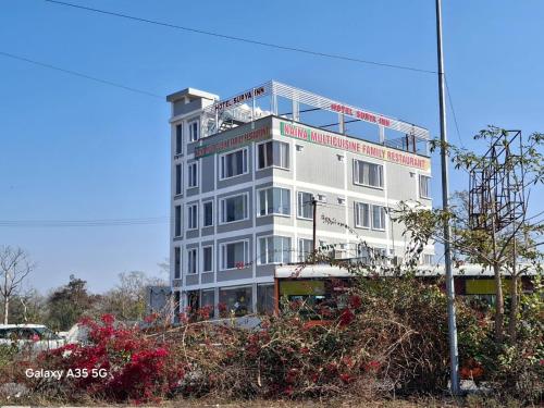 a white building with a sign on top of it at Hotel Surya Inn in Kānsrao