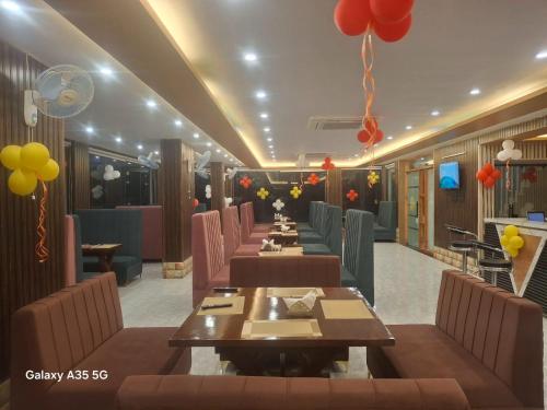 a restaurant with a row of tables and balloons at Hotel Surya Inn in Kānsrao