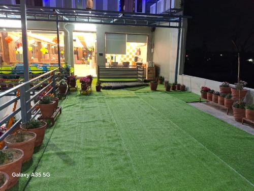 a patio with green grass and potted plants at Hotel Surya Inn in Kānsrao