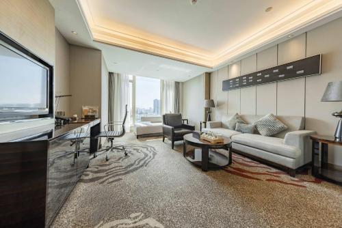 a living room with a couch and a television at Shenzhen LANGYUE International Hotel in Longgang