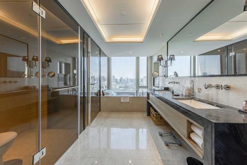 a bathroom with a shower and a sink and a tub at Shenzhen LANGYUE International Hotel in Longgang