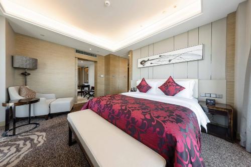 a bedroom with a large bed and a living room at Shenzhen LANGYUE International Hotel in Longgang