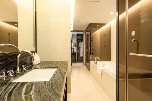 a bathroom with a sink and a tub at Shenzhen LANGYUE International Hotel in Longgang