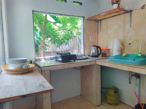 una cocina con fregadero y ventana en Kuta HomePod, en Kuta Lombok
