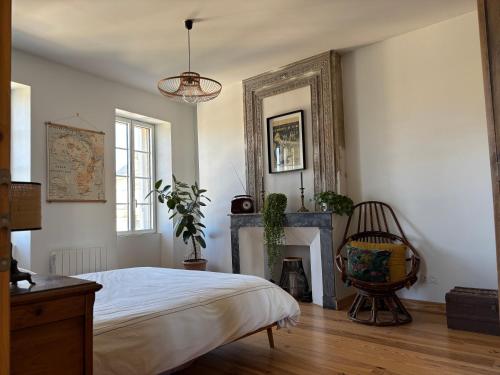 a bedroom with a bed and a fireplace at Château La Fon du Berger in Saint-Sauveur