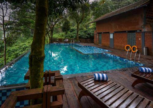 a swimming pool with a table and a pair of scissors in it at Vythiri Mist Resort in Vythiri