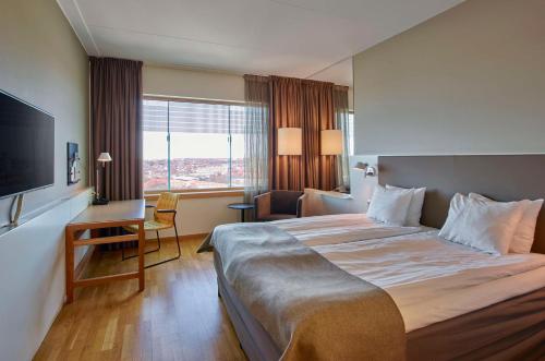 a hotel room with a large bed and a desk at Scandic Talk in Stockholm
