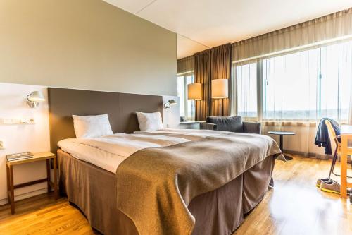 a hotel room with a large bed and a large window at Scandic Talk in Stockholm