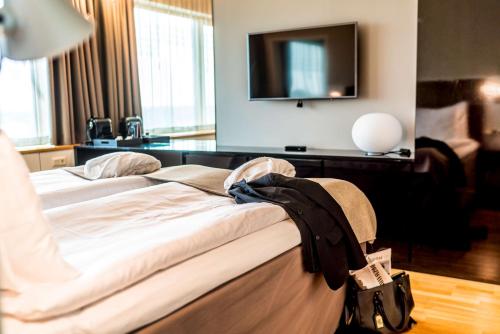 a bedroom with a bed with a tv on the wall at Scandic Talk in Stockholm