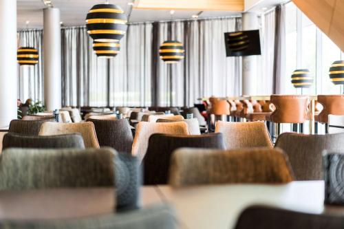 an empty restaurant with chairs and tables and lights at Scandic Talk in Stockholm