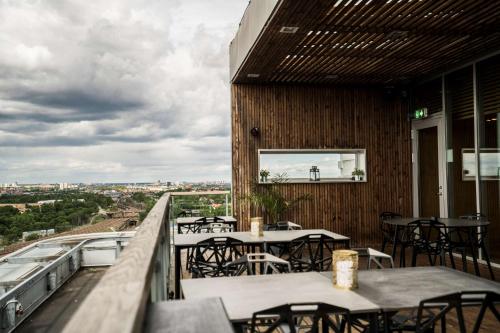 a restaurant with tables and chairs on a balcony at Scandic Talk in Stockholm