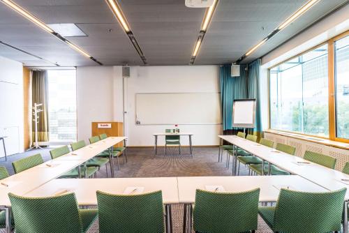 a conference room with tables and chairs and a whiteboard at Scandic Talk in Stockholm