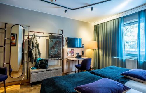 a bedroom with two beds and a desk and a mirror at Scandic Umeå Syd in Umeå