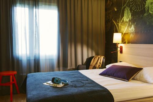 a hotel room with a bed with a camera on it at Scandic Uppsala Nord in Uppsala