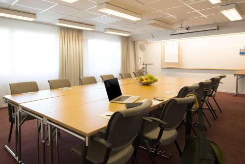 a conference room with a large table and chairs at Scandic Uppsala Nord in Uppsala