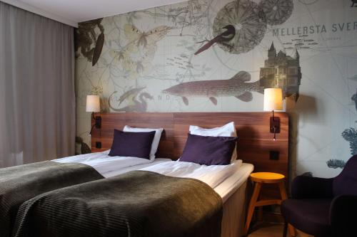 a hotel room with a bed with purple pillows at Scandic Sundsvall Nord in Sundsvall