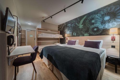 a hotel room with two beds and a desk at Scandic Västerås in Västerås