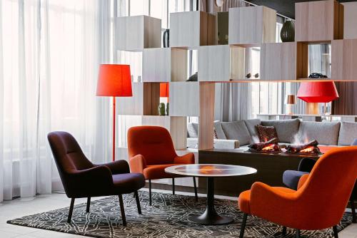 a living room with chairs and a table and a couch at Scandic Västerås in Västerås