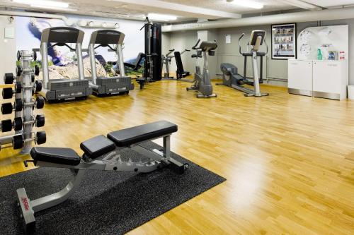 a gym with several tread machines and a hardwood floor at Scandic Östersund Syd in Östersund