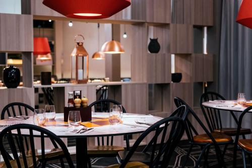 a dining room with tables and chairs with wine glasses at Scandic Östersund Syd in Östersund