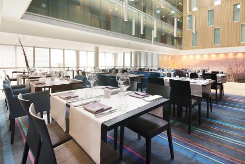 a dining room with tables and chairs and tablesktop at Scandic Stavanger Airport in Sola