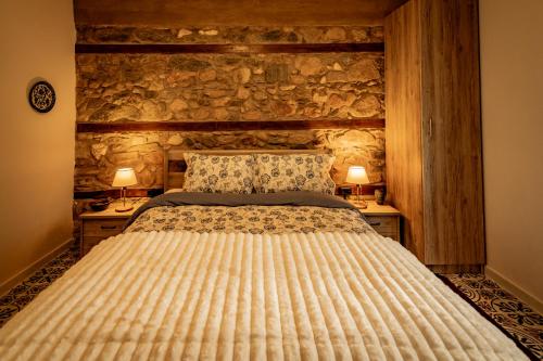 a bedroom with a bed and two night stands with lamps at Σοχός Παραδοσιακές Οικίες- ΒΕΝΙΖΕΛΟΥ in Zokhós
