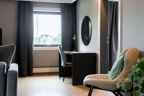 a living room with a desk and chairs and a window at Scandic Stavanger Park in Stavanger