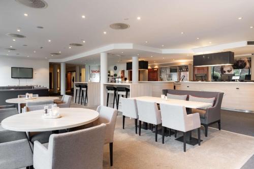 a restaurant with tables and chairs and a bar at Scandic Stavanger Park in Stavanger