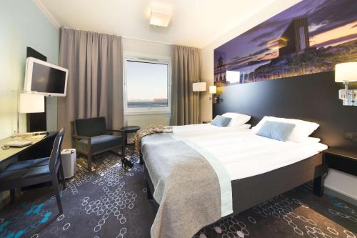 una camera d'albergo con un letto grande e una scrivania di Scandic Hammerfest a Hammerfest
