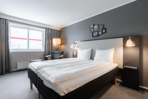 a bedroom with a large bed and a window at Scandic Bryggen in Honningsvåg