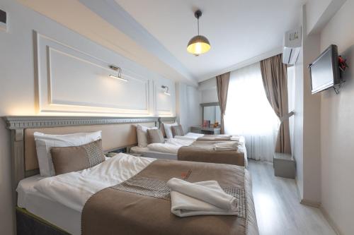 a row of three beds in a hotel room at Kuran Hotel International in Istanbul