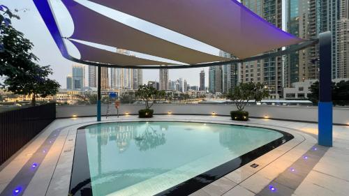 a swimming pool on the roof of a building at Gogoto1 Ultra LUX Burj View Spacious High Floor PS5 NYE Fireworks View in Dubai