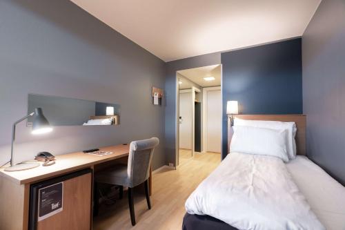 a hotel room with a bed and a desk and a bed and a desk at Scandic Vadsø in Vadsø