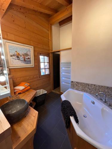 - une salle de bains pourvue d'une baignoire dans une cabine en bois dans l'établissement Appartement duplex megeve, à Megève