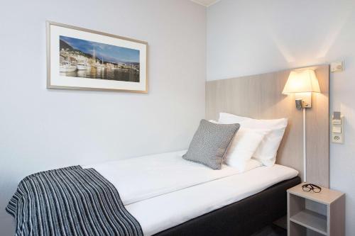 a bed in a hotel room with a picture on the wall at Scandic Byparken in Bergen