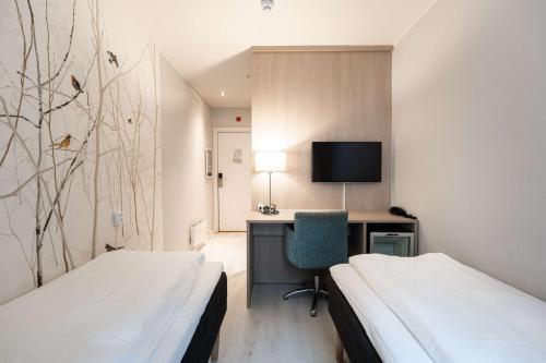 a hotel room with two beds and a desk with a computer at Scandic Byparken in Bergen