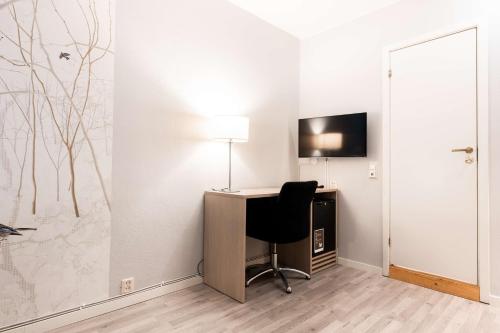 a room with a desk with a chair and a television at Scandic Byparken in Bergen