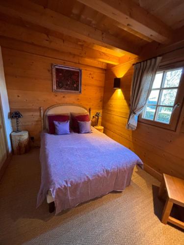 une chambre avec un lit dans une cabane en rondins dans l'établissement Appartement duplex megeve, à Megève