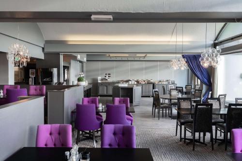 a dining room with purple chairs and tables at Scandic Vadsø in Vadsø
