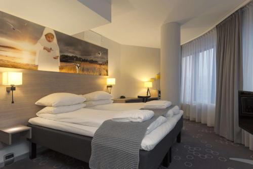 a hotel room with two beds and a painting on the wall at Scandic Narvik in Narvik
