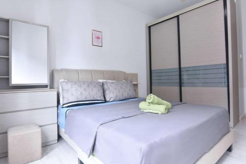a bedroom with a bed with a green pillow on it at Chic Suasana JB Suite Cozy Stay with Balcony in Johor Bahru