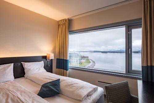 a hotel room with a bed and a large window at Scandic Seilet Hotel in Molde