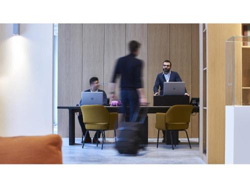 three men sitting at a table with their laptops at 9Hotel Sablon in Brussels